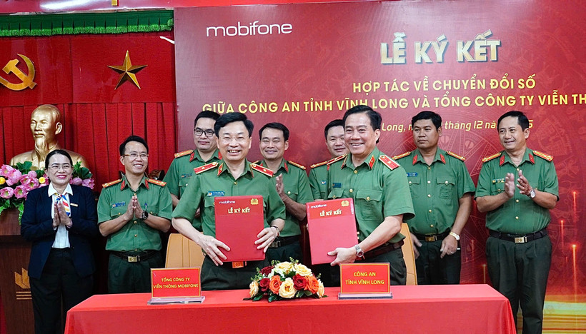 Thiếu tướng Trương Sơn Lâm - Chủ tịch MobiFone và Thiếu tướng Nguyễn Thanh Hải - Giám đốc Công an tỉnh Vĩnh Long trao văn bản hợp tác. (Ảnh: PV/Vietnam+)