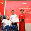 Tổng Biên tập Lê Quốc Minh nhận bản thảo bài hát "Như có Bác trong ngày đại thắng" có chữ ký đề tặng của nhạc sỹ Phạm Tuyên. (Ảnh: CTV/Vietnam+) 