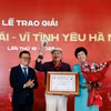 Ông Lê Quốc Minh, Ủy viên Trung ương Đảng, Chủ tịch Hội Nhà báo Việt Nam, Tổng Biên tập Báo Nhân Dân và Tổng Giám đốc Thông tấn xã Việt Nam Vũ Việt Trang trao Giải thưởng Lớn cho nhạc sỹ Trần Tiến. (Ảnh: Huy Thông/TTXVN)