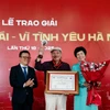 Ông Lê Quốc Minh, Ủy viên Trung ương Đảng, Chủ tịch Hội Nhà báo Việt Nam, Tổng Biên tập Báo Nhân Dân và Tổng Giám đốc Thông tấn xã Việt Nam Vũ Việt Trang trao Giải thưởng Lớn cho nhạc sỹ Trần Tiến. (Ảnh: Huy Thông/TTXVN)