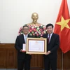 Ủy viên Trung ương Đảng, Thứ trưởng Bộ Ngoại giao Nguyễn Mạnh Cường trao Bằng khen và Huân chương Hữu nghị cho Đại sứ Denny Abdi. (Ảnh: Thành Long)