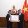 Ủy viên Trung ương Đảng, Thứ trưởng Bộ Ngoại giao Nguyễn Mạnh Cường trao Bằng khen và Huân chương Hữu nghị cho Đại sứ Denny Abdi. (Ảnh: Thành Long)