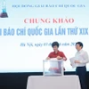 Tổng Giám đốc Thông tấn xã Việt Nam - bà Vũ Việt Trang và nhà báo Hồ Quang Lợi, thành viên Hội đồng chung khảo bỏ phiếu chấm các tác phẩm. (Ảnh: Minh Quyết/TTXVN)