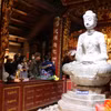 Người dân chiêm bái tượng Phật A Di Đà - Bảo vật Quốc gia bằng đá ở chùa Phật Tích. (Ảnh: Thanh Thương/TTXVN)