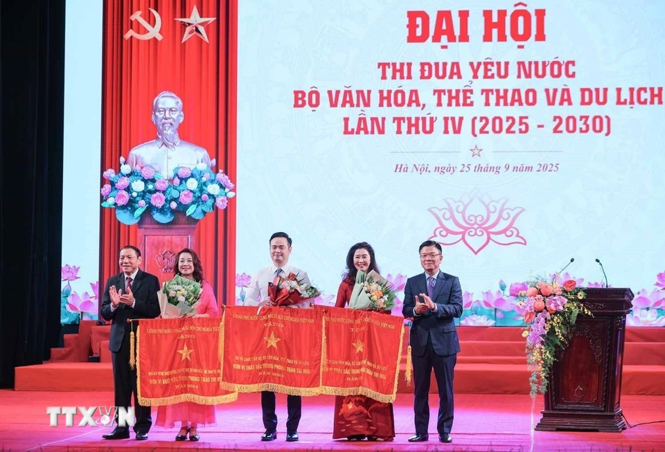 Phó Thủ tướng Lê Thành Long và Bộ trưởng Bộ Văn hóa, Thể thao và Du lịch Nguyễn Văn Hùng trao cờ thi đua của Chính phủ cho các đơn vị đạt thành tích xuất sắc. (Ảnh: Hoàng Hiếu/TTXVN)