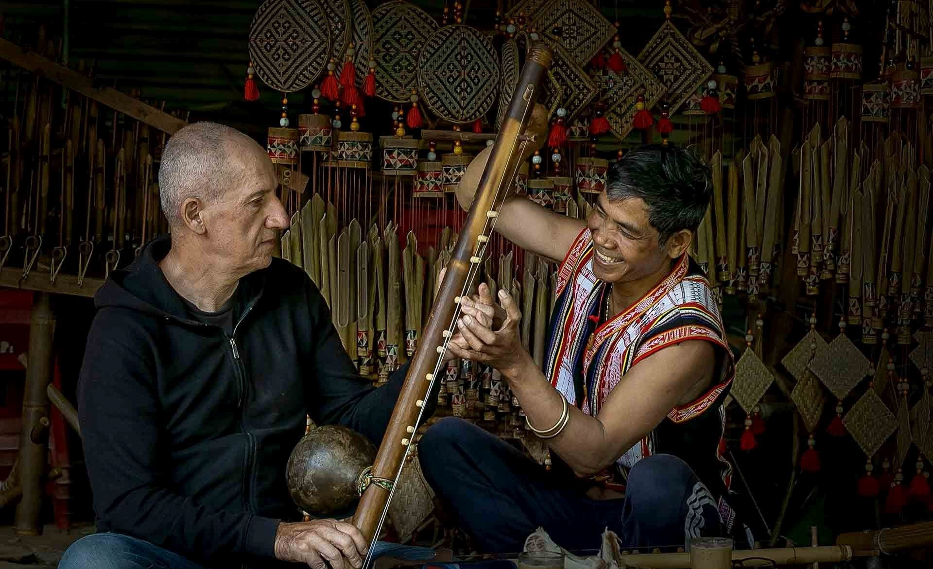 Du khách quốc tế học cách chơi nhạc cụ Tây Nguyên với người dân bản địa. (Nguồn ảnh: Cục Du lịch Quốc gia Việt Nam)