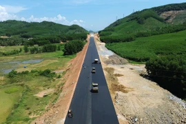 Nhà thầu thi công thảm bêtông nhựa nền đường một tuyến cao tốc. (Ảnh: Khánh Hùng/Vietnam+)