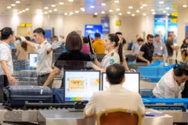Nhân viên an ninh hàng không tại Sân bay Quốc tế Nội Bài kiểm tra hành khách qua cửa soi chiếu. (Ảnh: PV/Vietnam+)