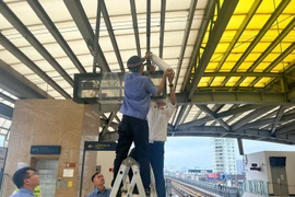Nhân viên Hà Nội Metro che chắn bảng điện tử tại một sân ga của tuyến đường sắt đô thị Cát Linh-Hà Đông. (Ảnh: PV/Vietnam+)