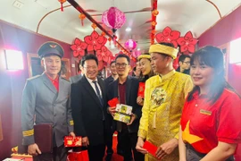 Lãnh đạo Tổng công ty Đường sắt Việt Nam tặng quà, lì xì, chúc Tết hành khách, nhân viên tàu trên "Chuyến tàu Xuân". (Ảnh: PV/Vietnam+)