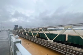 Điều tàu chở hàng ra trấn giữ 2 cầu đường sắt tại Huế do lũ dâng trở lại. (Ảnh: VNR cung cấp)