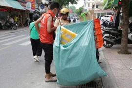 Một tài xế chạy ứng dụng gọi xe giao hàng bị lực lượng cảnh sát giao thông xử lý vi phạm che biển số. (Ảnh: PV/Vietnam+)