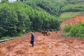Lực lượng chức năng đang nỗ lực khắc phục các vị trí sạt lở do mưa lũ để thông đường sớm nhất. (Ảnh: PV/Vietnam+)