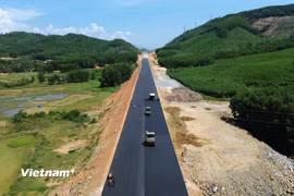 Nhà thầu thi công thảm bêtông nhựa nền đường một tuyến cao tốc. (Ảnh: Khánh Hùng/Vietnam+)