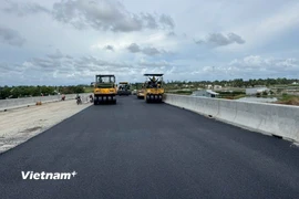 Nhà thầu huy động máy móc thi công thảm nhựa nền đường. (Ảnh: Việt Hùng/Vietnam+)