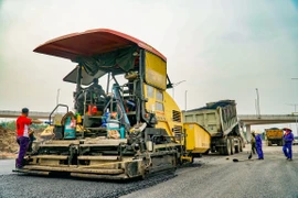 Nhà thầu thi công nâng cấp, cải tạo mặt đường tại một tuyến quốc lộ. (Ảnh: Minh Hiếu/Vietnam+)