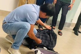 Kiểm tra hành lý xách tay của hành khách nói đùa có bom ngay khi vừa hạ cánh tại Sân bay Nội Bài. (Ảnh: PV/Vietnam+)