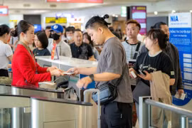 Hành khách xếp hàng làm thủ tục tại cửa ra tàu bay tại Cảng hàng không Quốc tế Nội Bài. (Ảnh: PV/Vietnam+)