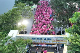 Khoảnh khắc tập thể bứt tốc, khi vận động viên khiếm thị và bạn dẫn cùng hòa nhịp, biến đường chạy thành bản giao hưởng yêu thương của mùa thu Hà Nội. (Ảnh: VNA).