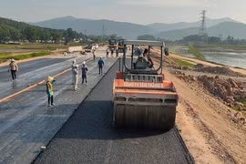 Nhà thầu thi công thảm nhựa nền đường một dự án đường bộ cao tốc. (Ảnh: Việt Hùng/Vietnam+)