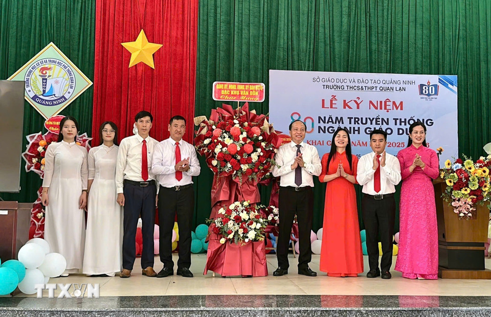 Lãnh đạo đặc khu Vân Đồn (Quảng Ninh) tặng hoa cho trường Trung học cơ sở và Trung học phổ thông Quan Lạn. (Ảnh: TTXVN phát)
