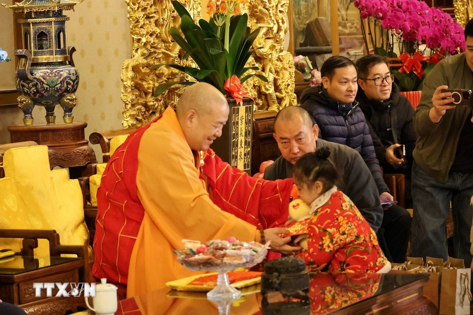 Các cháu nhỏ được Trụ trì của Ling Quang Tự tặng quà nhân dịp đầu năm mới. (Ảnh: Quang Hưng/TTXVN).