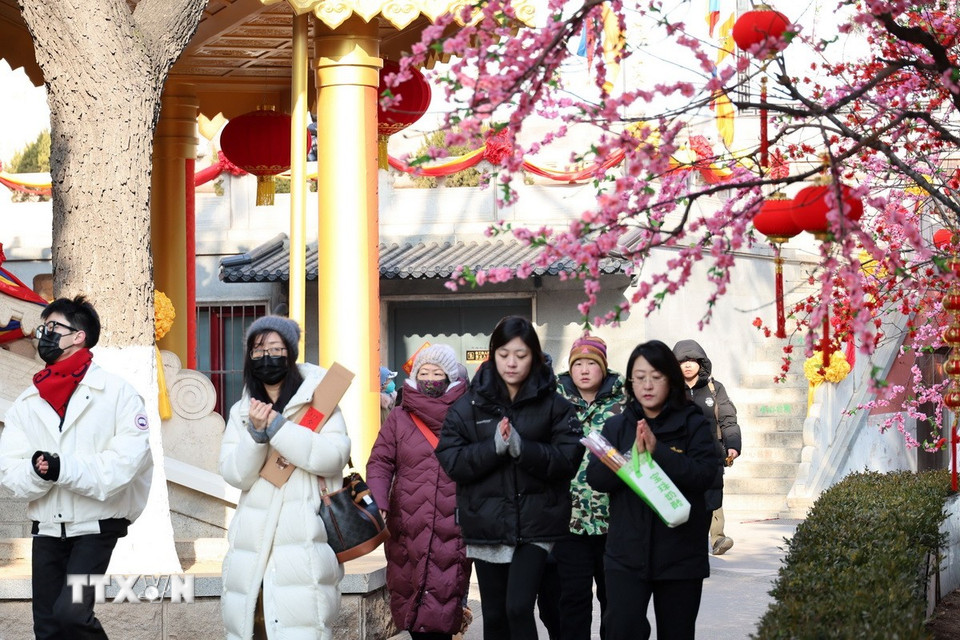Người dân Trung Quốc vãn cảnh chùa và cầu mong một năm mới hạnh phúc, an khang. (Ảnh: Quang Hưng/TTXVN).
