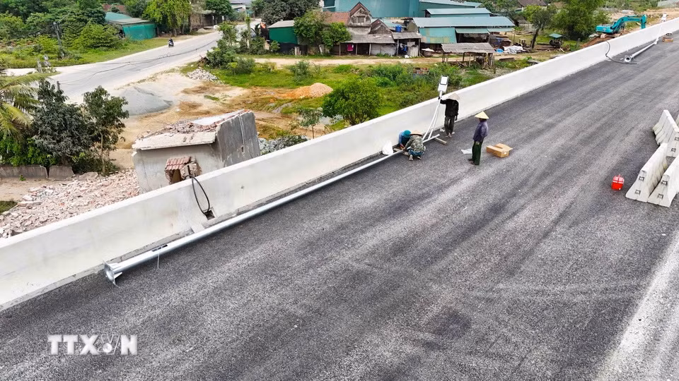 Công nhân lắp đặt hệ thống chiếu sáng tại dự án thành phần đoạn Bãi Vọt-Hàm Nghi. (Ảnh: Hữu Quyết/TTXVN)