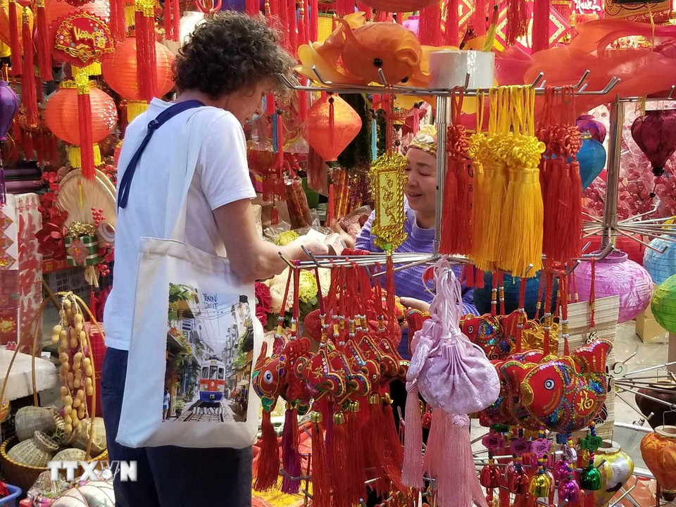 Du khách quốc tế hòa chung với không khí mua sắm tại phố Hàng Mã, Hà Nội. (Nguồn: Thái Hà/ Vietnam+)