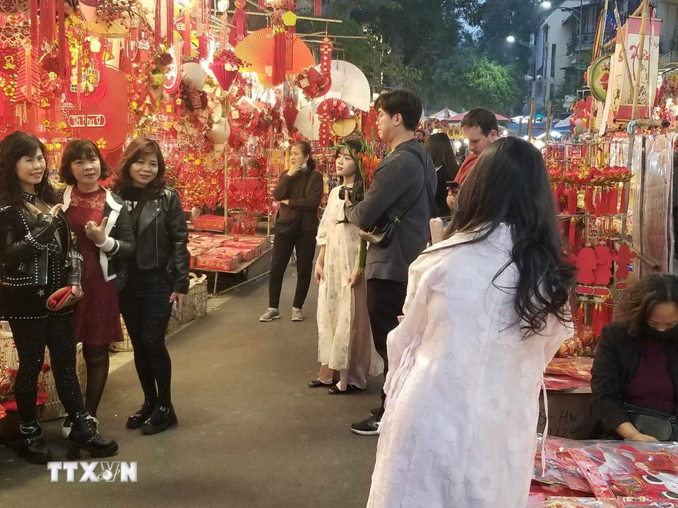 Các cửa hàng rực rỡ đồ trang trí Tết thu hút người dân và các bạn trẻ đến xem và chụp ảnh. (Nguồn: Thái Hà/Vietnam+)