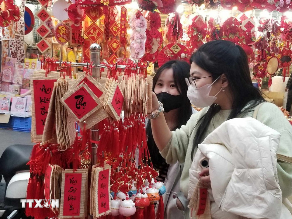 Các bạn trẻ thích thú với những sản phẩm trang trí nhỏ xinh. (Nguồn: Thái Hà/Vietnam+)