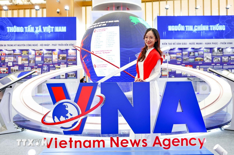 Khách tham quan check in tại gian trưng bày ấn tượng, phong cách hiện đại của TTXVN. (Ảnh: Thanh Tùng/TTXVN)