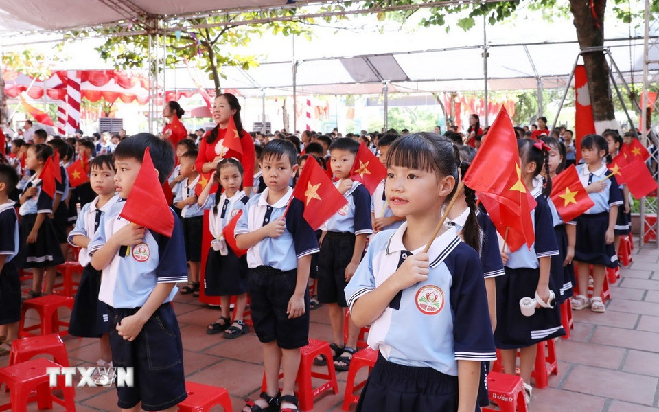 Học sinh trường Tiểu học Ninh Giang, phường Tây Hoa Lư, tỉnh Ninh Bình, thực hiện nghi lễ chào cờ cùng các điểm cầu cả nước. (Ảnh: Đức Phương/TTXVN)