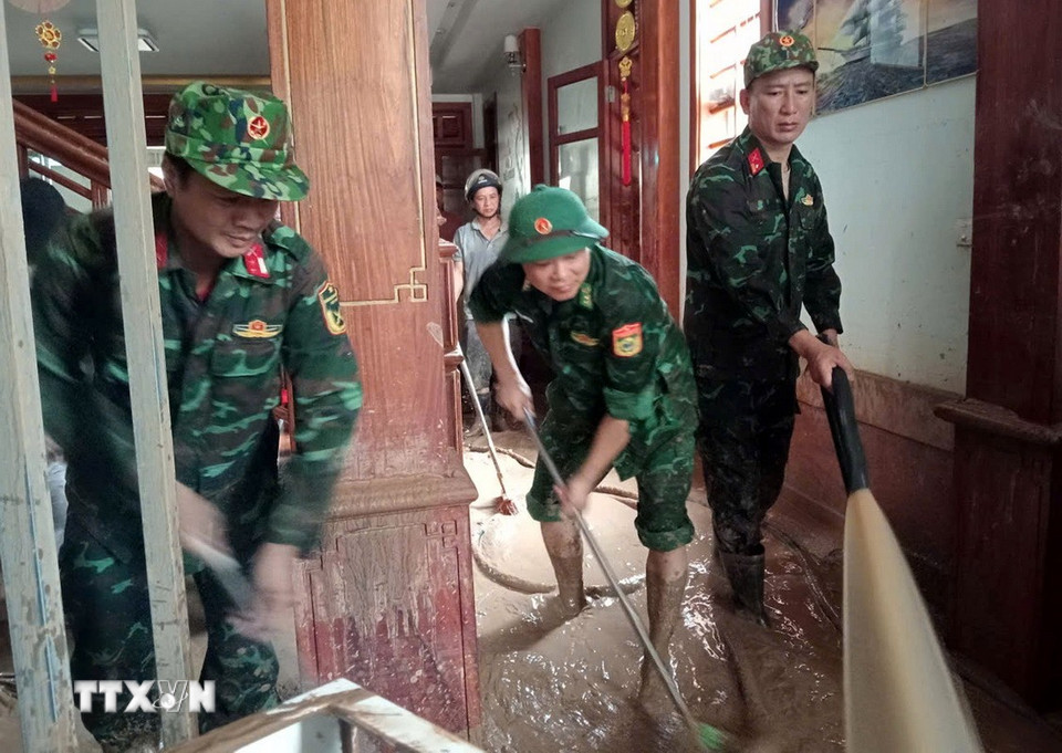 Cán bộ, chiến sỹ Đồn biên phòng Nậm Cắn giúp người dân xã Mường Xén (Nghệ An) dọn dẹp, khắc phục hậu quả sau lũ. (Ảnh: TTXVN phát)