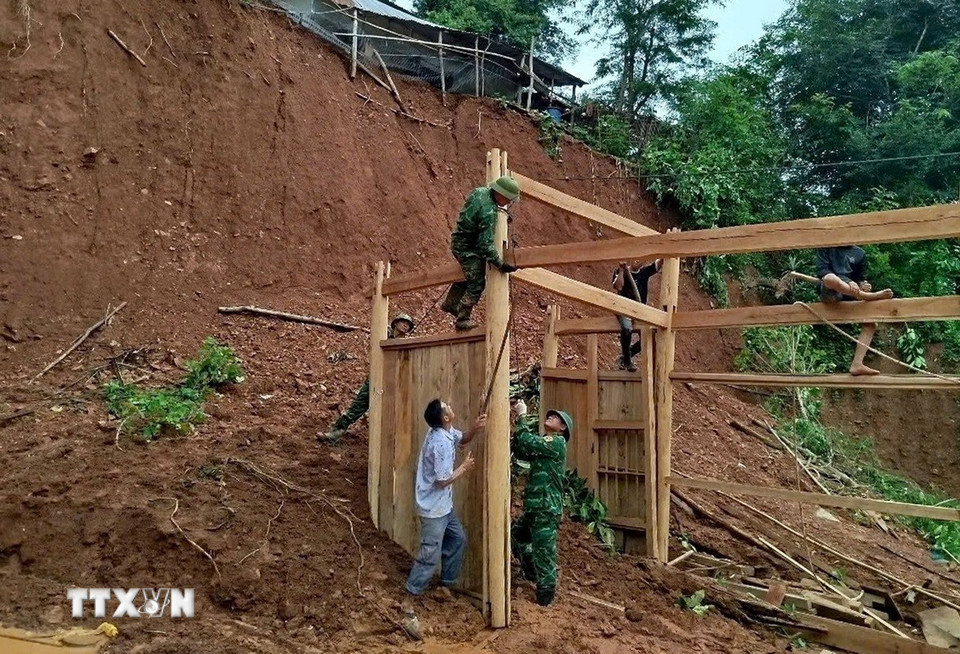 Cán bộ, chiến sỹ Đồn biên phòng Keng Đu (Nghệ An) giúp người dân địa phương khắc phục hậu quả sau bão lũ. (Ảnh: TTXVN phát)