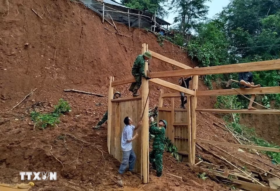 Cán bộ, chiến sỹ Đồn biên phòng Keng Đu (Nghệ An) giúp người dân địa phương khắc phục hậu quả sau bão lũ. (Ảnh: TTXVN phát)