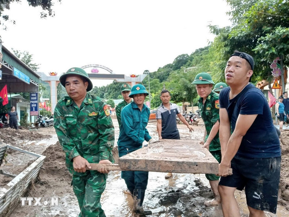 Cán bộ, chiến sỹ Đồn biên phòng Nậm Cắn giúp người dân xã Mường Xén (Nghệ An) dọn dẹp, khắc phục hậu quả sau lũ. (Ảnh: TTXVN phát)