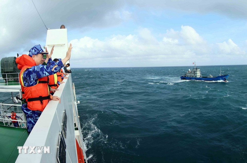 Trung tướng Bùi Quốc Oai và thành viên đoàn công tác của Bộ Tư lệnh Cảnh sát biển Việt Nam gửi lời chào tới tàu KG 96029 TS làm nhiệm vụ xuyên Tết. (Ảnh: An Đăng/TTXVN)