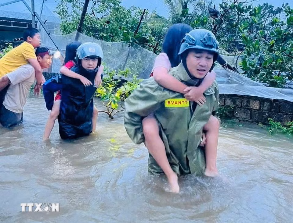Lực lượng công an Thanh Hóa giải cứu người dân ra khỏi khu vực ngập lụt đến nơi an toàn. (Ảnh: TTXVN phát)