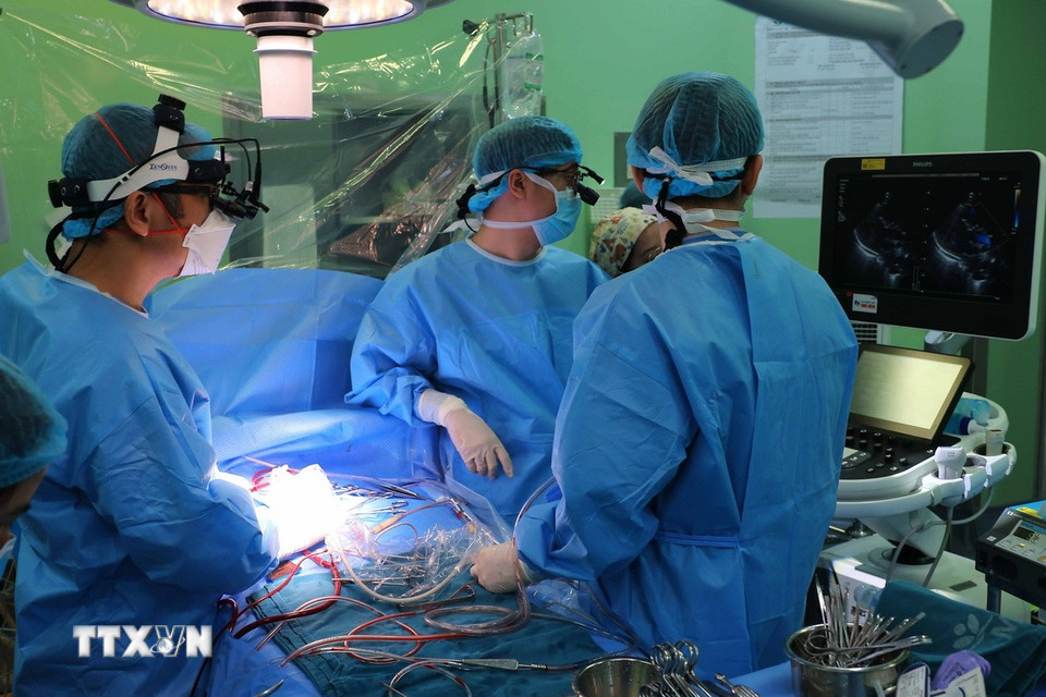PGS.TS. Nguyễn Lý Thịnh Thường (bác sỹ mổ chính, bên trái) và đội ngũ bác sỹ Bệnh viện Nhi Trung ương tiến hành phẫu thuật cho trẻ sơ sinh bị dị tật tim bẩm sinh. (Ảnh: Hoàng Hiếu/TTXVN)