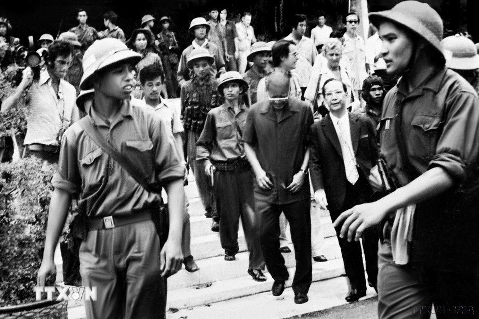 Đại úy Phạm Xuân Thệ (bên phải), Trung đoàn phó Trung đoàn 66, Sư đoàn 304 (Quân đoàn 2) cùng các chiến sỹ Quân giải phóng dẫn giải Tổng thống Dương Văn Minh và Thủ tướng Vũ Văn Mẫu của Ngụy quyền Sài Gòn tới Đài Phát thanh để đọc lời tuyên bố đầu hàng vô điều kiện. (Ảnh: TTXVN)