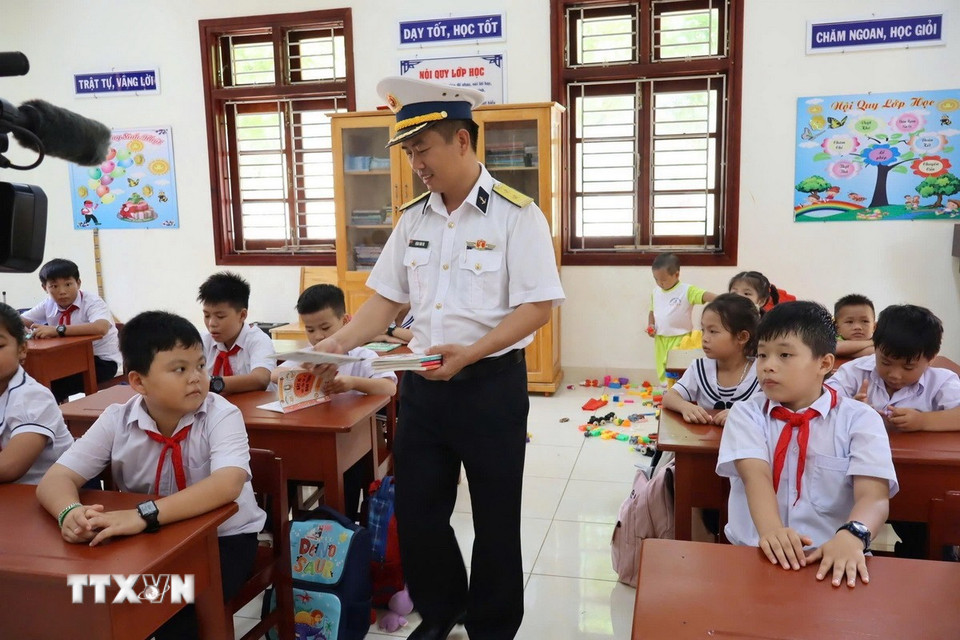 Lãnh đạo chỉ huy đảo Đá Tây tặng sách vở cho học sinh trường Tiểu học Trường Sa nhân dịp năm học mới. (Ảnh: TTXVN phát)