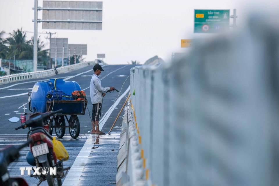 Lực lượng thi công tiếp tục vệ sinh, xử lý các chi tiết cuối cùng trên tuyến cao tốc. (Ảnh: Thanh Liêm/TTXVN)