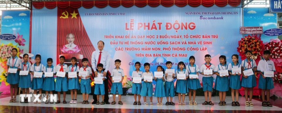 Bí thư Tỉnh ủy Cà Mau Nguyễn Hồ Hải trao học bổng cho các học sinh có hoàn cảnh khó khăn. (Ảnh: Tuấn Kiệt/TTXVN)