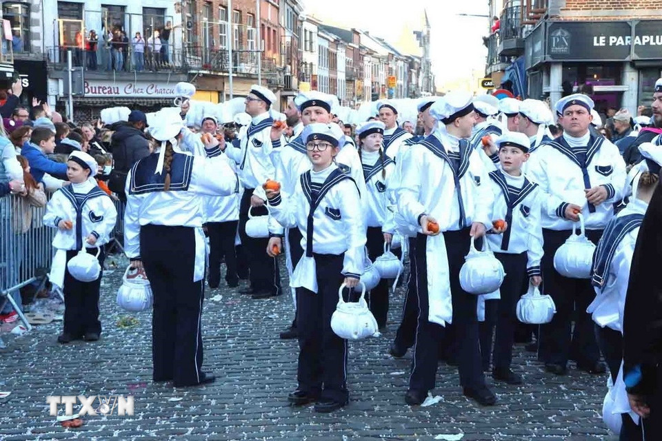 Một đoàn Gilles diễu hành và ném cam cho đám đông. (Ảnh: Hương Giang/TTXVN)