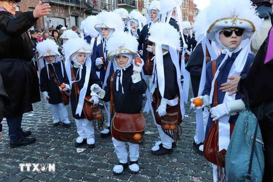 Trẻ em hóa trang thành các "Gilles" và mang những giỏ cam máu ném cho du khách. (Ảnh: Hương Giang/TTXVN)