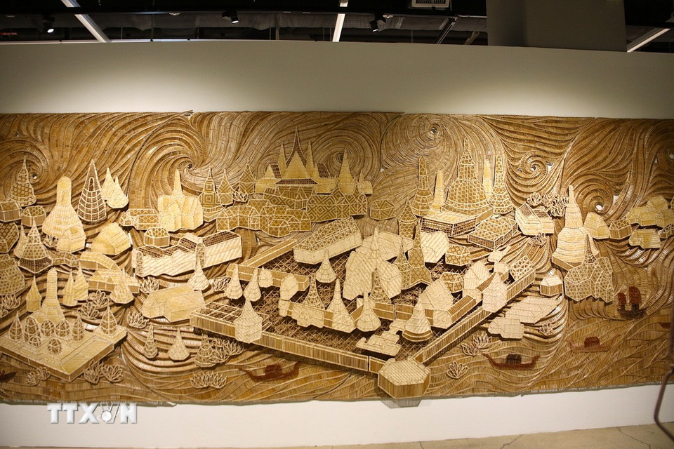 Korakot Aromondee (Thái Lan) với tác phẩm điêu khắc gỗ. (Ảnh: Khánh Vân/TTXVN)