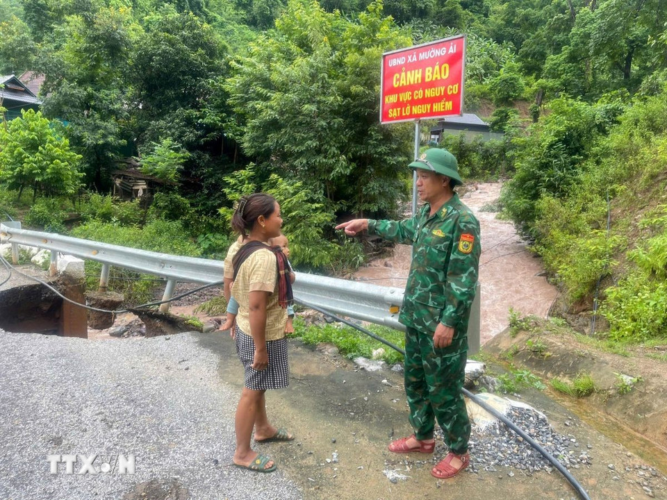 Cán bộ, chiến sỹ Đồn biên phòng Mường Ải cảnh báo người dân cẩn thận khi qua khu vực bị sạt lở. (Ảnh: TTXVN phát)