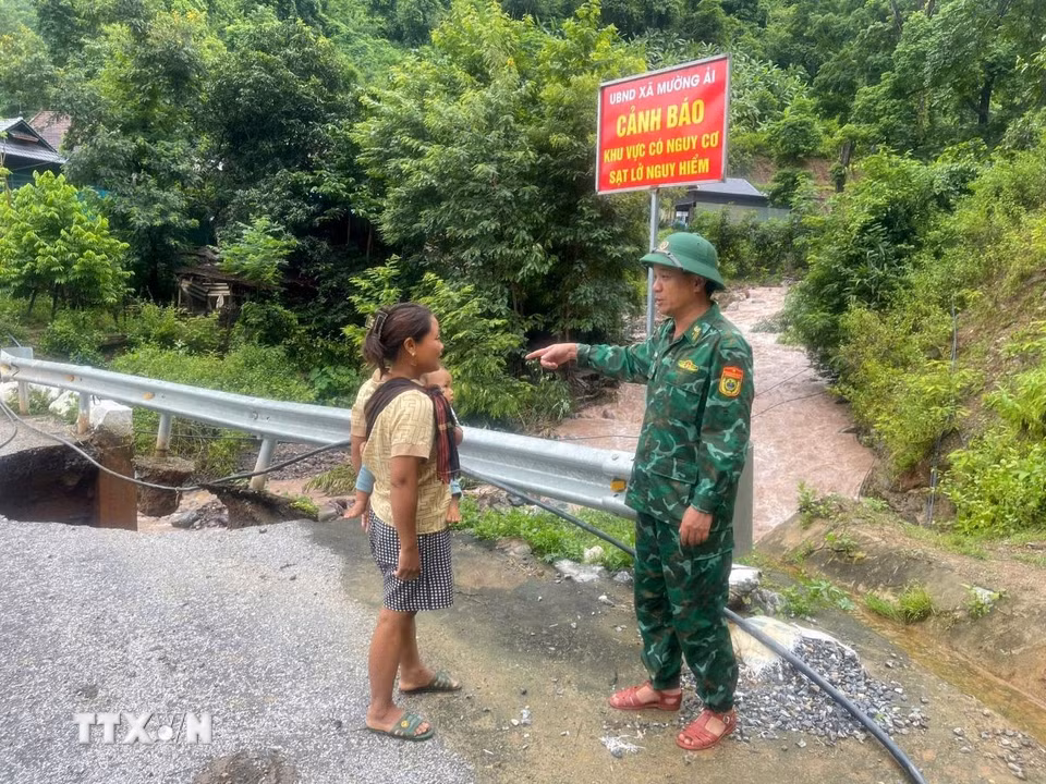Cán bộ, chiến sỹ Đồn biên phòng Mường Ải cảnh báo người dân cẩn thận khi qua khu vực bị sạt lở. (Ảnh: TTXVN phát)