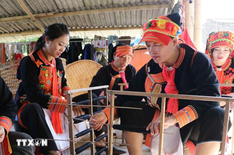 Phụ nữ Dao tự kéo sợi, may trang phục truyền thống cho mình. (Ảnh: Nguyễn Oanh/TTXVN)